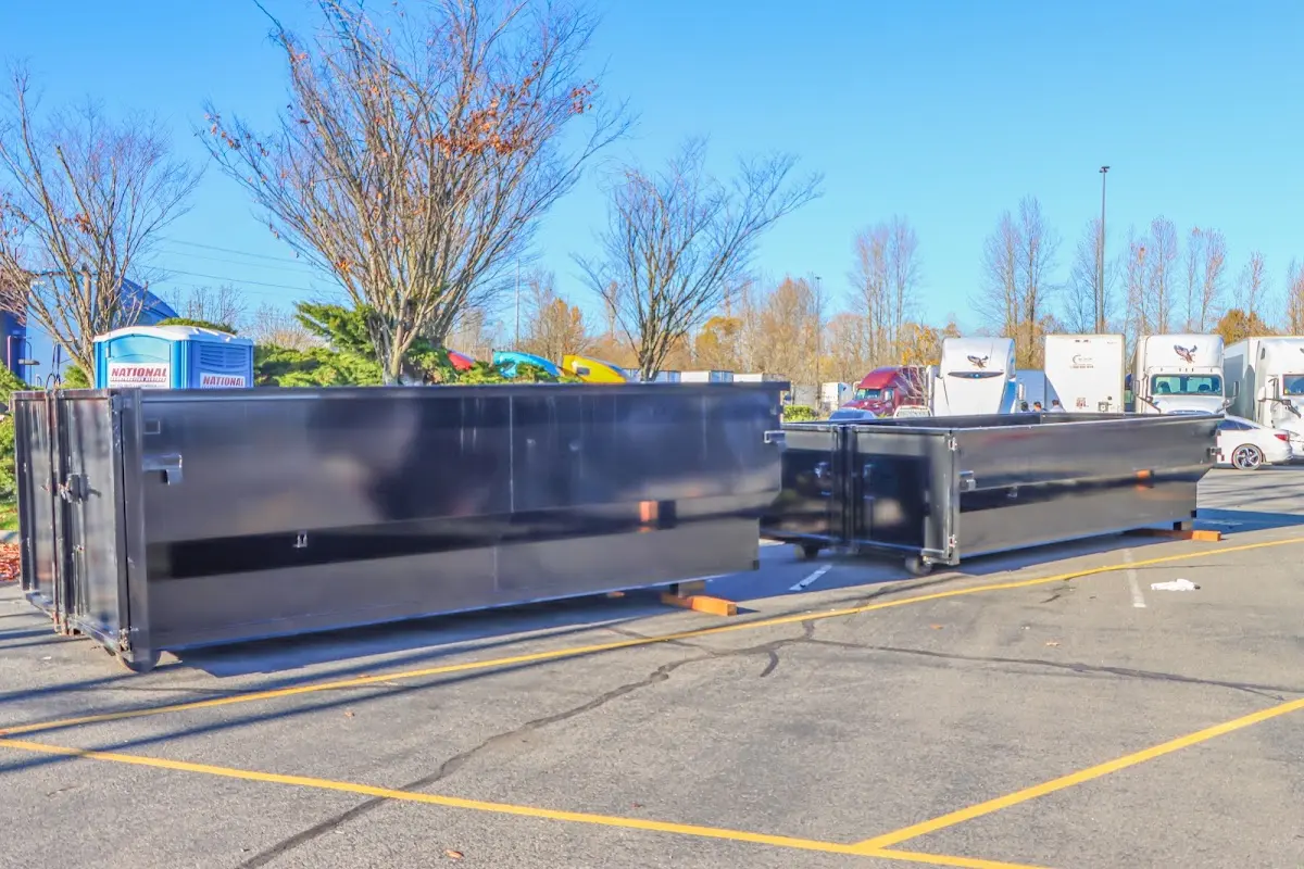 Professional dumpster rental service with roll-off container on residential driveway in Monfort Heights